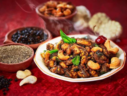 A plate full of chicken and cashews along with pepper, creating a flavorful and aromatic dish.