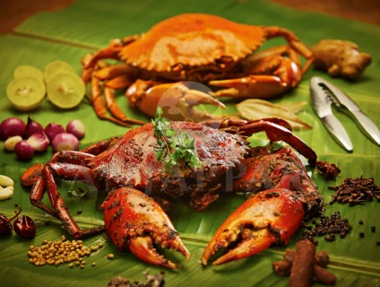 A delicious crab fry presented artistically on a banana leaf with a tempting spread of food.