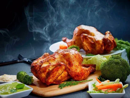 Delicious two grill chicken on a cutting board ready to served with vegies,mayo and mint chutney