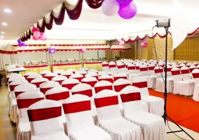A banquet hall with elegant seating arrangements and space for the buffet, lighting, and stage.
