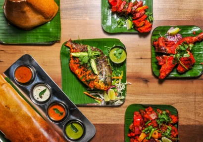 A variety of fried fish, chicken, prawns with sauces, and dosa with different chutneys.