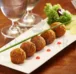 A plate of chicken balls garnished by spring onion & lettuce served alongwith two glasses of water.