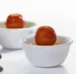 Two white bowls filled with mouthwatering, perfectly textured gulab jamun dipped in sugar syrup