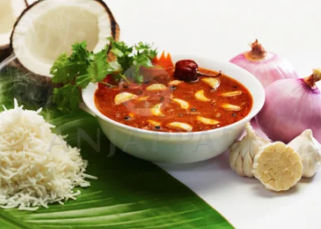 On a banana leaf, rice with a savory bowl of curry bursting with rich flavors and aromatic spices