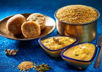 Two bowls of sweet dhal payasam made with the ingredients dhal, jaggery, cashew, and cardamom